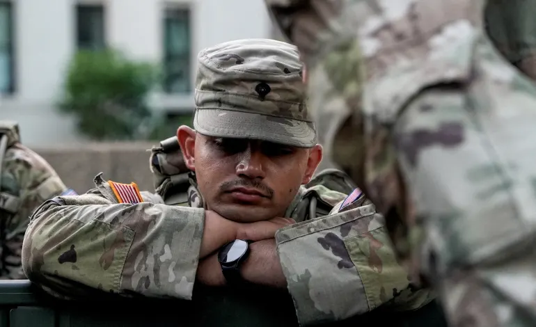 A member of the National Guard rests, after sunrise, as day breaks ahead of Fourth of July celebrations marking the 250th anniversary of U.S. Independence, in Washington, D.C., U.S., July 4, 2026. REUTERS/Cheney Orr     