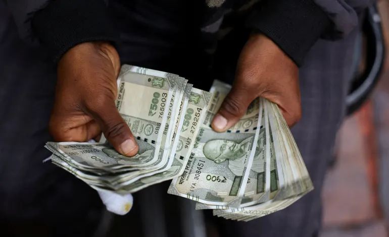 A man counts Indian currency notes at a roadside currency exchange stall in the old quarters of Delhi, India, February 2, 2026. Anushree Fadnavis