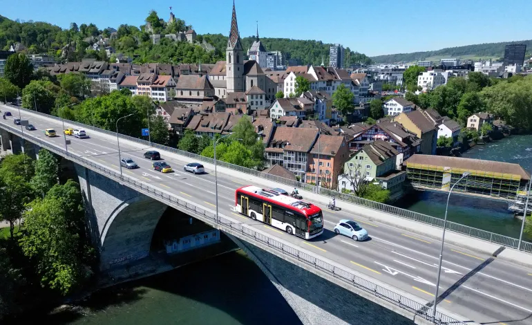 A drone view shows the "Line Zero" bus, an artistic experiment by Frank and Patrik Riklin designed to encourage social interaction and mindful travel by operating without a fixed route or destination, allowing passengers to board and leave freely as it moves through the Baden‑Wettingen area, near Zurich, arriving at its stop in Baden, Switzerland, April 30, 2026. Denis Balibouse