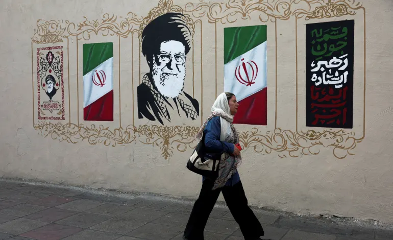 A woman walks by a mural depicting Iran's late Supreme Leader Ayatollah Ali Khamenei, on a street in Tehran, Iran, August 13, 2026. Majid Asgaripour/WANA (West Asia News Agency) via