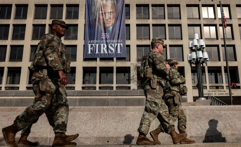Members of the National Guard walk past the U.S. Department of Labor, which published its weekly initial jobless claims report for the week ending January 3, in Washington, D.C., U.S., January 8, 2026. REUTERS/Evelyn Hockstein   