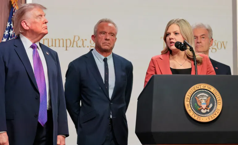 Centre for Medicare & Medicaid Services Administrator Dr Mehmet Oz, U.S. Health and Human Services Secretary Robert F. Kennedy Jr., and U.S. President Donald Trump stand as Heidi Overton speaks during an event to deliver remarks about health care costs and affordability from an auditorium on the White House campus in Washington, D.C., U.S., May 18, 2026. Jonathan Ernst