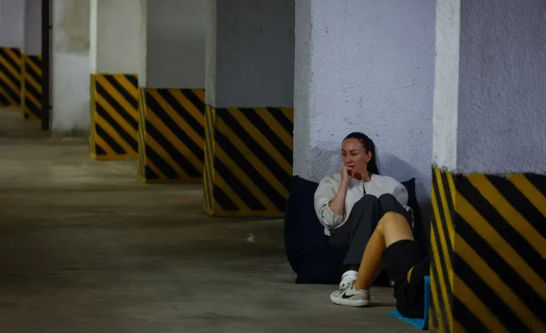 A woman takes a shelter inside an underground parking during Russian missile and drone strikes, amid Russia's attack on Ukraine, in Kyiv, Ukraine August 20, 2026. REUTERS/Valentyn Ogirenko