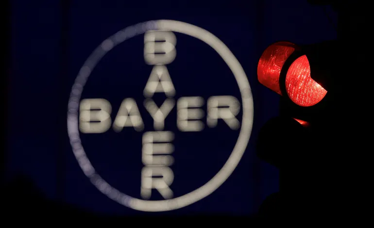 The 120 metres high Bayer Cross, logo of German pharmaceutical and chemical maker Bayer AG, consisting of 1710 LED glass bulbs, is seen next to a red traffic light in Leverkusen, Germany, September 23, 2023.  Wolfgang Rattay